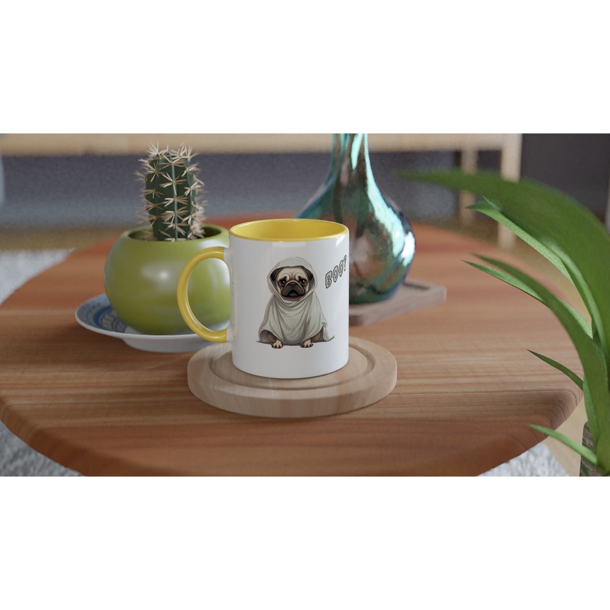 Round, wooden end table with a potted cactus, glass vase, and white mug on it. The mug has a yellow handle, rim, and inside with a fawn-colored cartoon-style pug on it. The pug has a concerned expression and is wearing a ghost costume. The word "Boo?" is on the right side of the image.