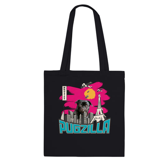 Black tote bag with the im age of a black pug standing over a cityscape under a pink sky with jets dropping bombs on him and with the word "Pugzilla" under it.