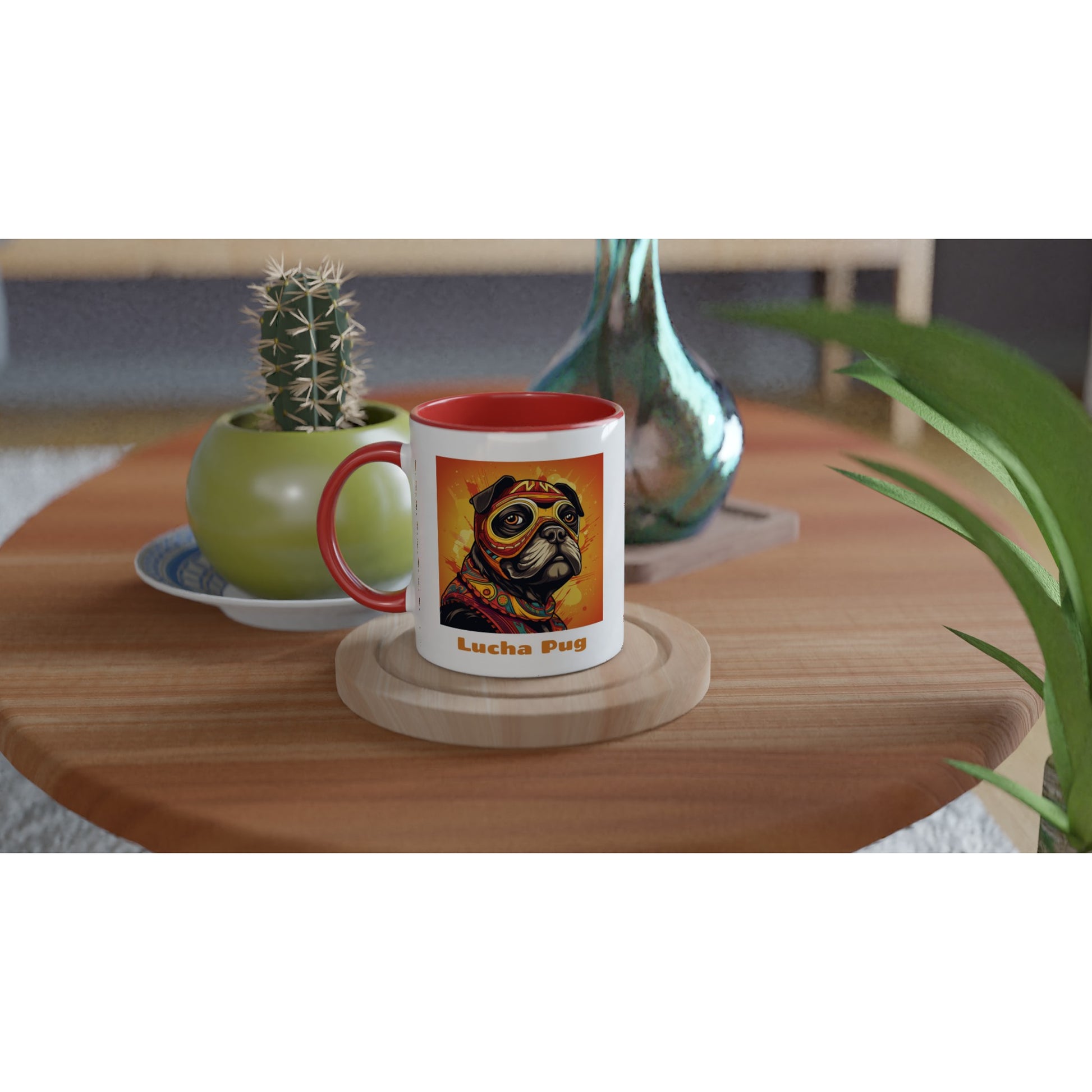 Round wooden end table with a potted cactus and a glass vase on it. There is also a white mug with a red handle, rim, and inside with the bust of a cartoon pug wearing an orange, red, and yellow luchador mask and costume on a fiery orange and yellow background on a round wooden coaster.